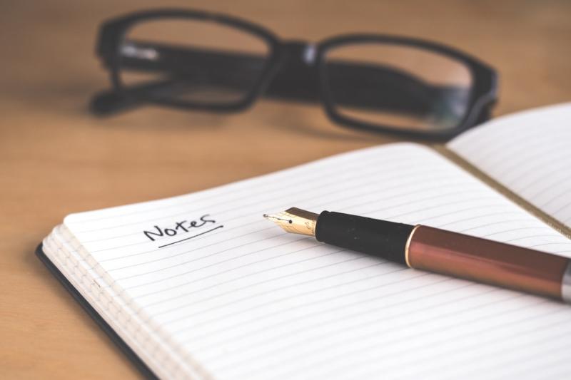 A writing desk with vintage pen, paper, and scattered poetry books