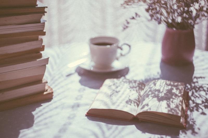 An open book with poetry verses illuminated by candlelight